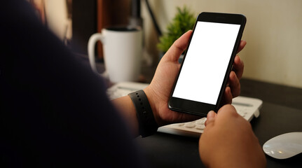 Mock up smartphone of hand holding black mobile phone with blank white screen.