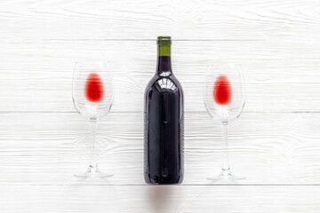 Wine bottle and glasses on white background from above