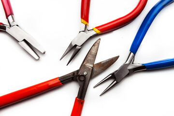 Different goldsmiths tools on the jewelry workplace. Desktop for craft jewelry making with professional tools. White background. 