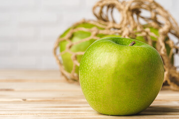 Green apple on wooden table, close up