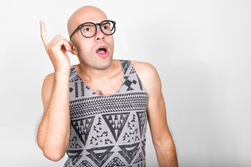 Portrait of bald nerd man with eyeglasses pointing up and having idea