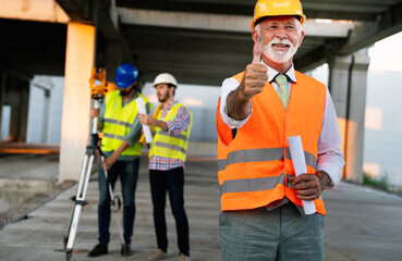 Confident construction engineer, architect, businessman in hardhat working on building site