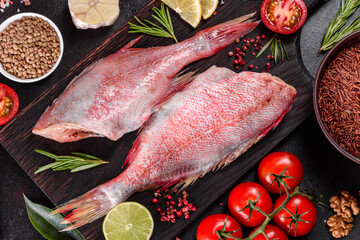 Raw fillet of red sea perch prepared for baking with spices and herbs