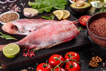 Raw fillet of red sea perch prepared for baking with spices and herbs