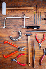 Different goldsmiths tools on the jewelry workplace. Desktop for craft jewelry making with professional tools.