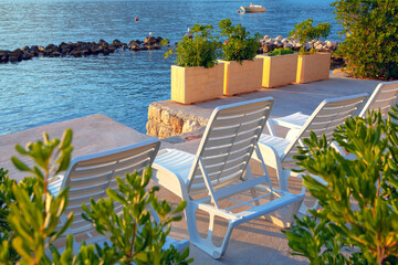 White sun loungers on a private beach . Perfect place on a seaside