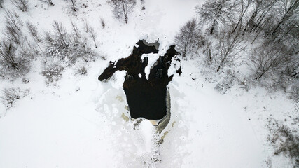 Aerial view of a winter lake with snow in the forest