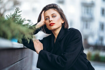Close up portrait of young woman with short haircut and red lips outdoors