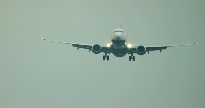 
The plane is landing at the airport. Purchase plan of an airplane with lights on, which flies to land on a blue sky.