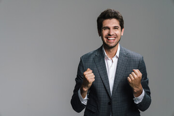 Photo of excited handsome businessman making winner gesture on camera