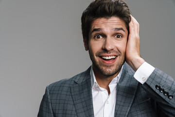 Photo of excited handsome businessman expressing surprise on camera