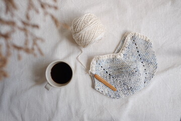 Top view crocheting the cotton bag on the white bed