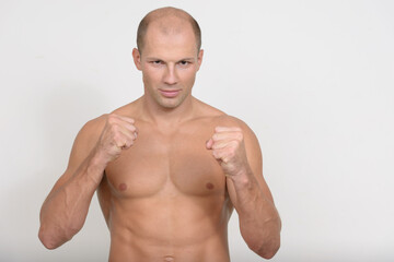 Stressed young muscular bald man ready to fight shirtless