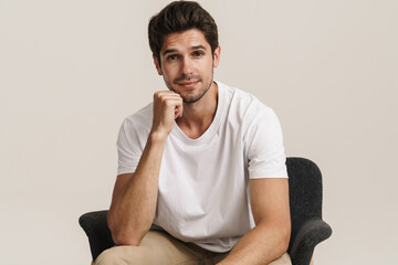 Portrait of man looking at camera while sitting on armchair