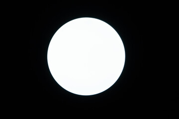 Circular light bulb on the ceiling on black background.