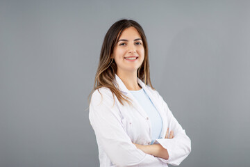 Beautiful Turkish woman doctor with warm and confident smiling in a grey background studio with...
