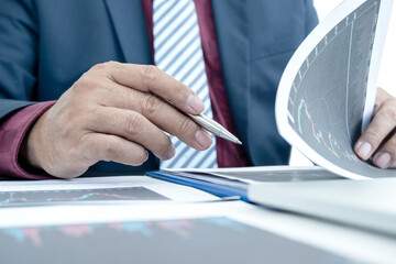 Hand of businessmen are planning business investments related to shares By analyzing and...