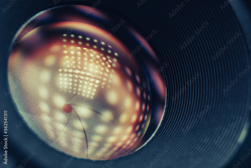 Poster beautiful camera lens on a dark with yellow shine reflection light background. macro view.