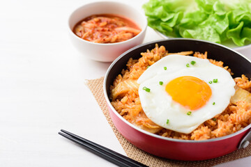 Kimchi fried rice with fried egg on top in cooking pan eating with fresh kimchi cabbage, Korean food