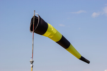 yellow-black wind indicator against the blue sky
