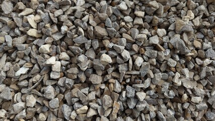 The texture of stone gravel gray. Stone rubble gray poured pile close-up.