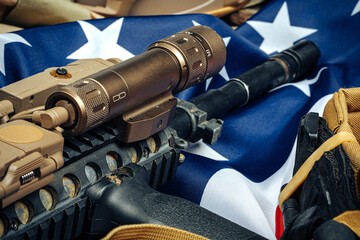 U.S. battle flag and assault rifle on the wooden table.