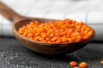 Wooden spoon with red lentils close up