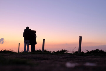 silhouette of a man hugging a woman on a hill