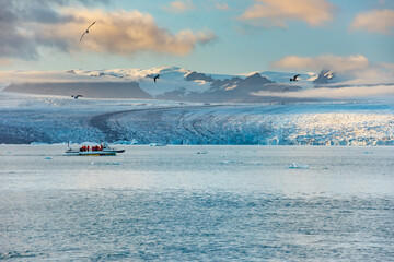 Icebergs floating in Jokulsarlon glacier lagoon lake at sunset. Great tourist attraction in Iceland Gold Circle.
