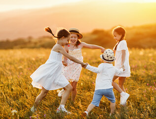 Happy kids having fun in nature in summer evening.