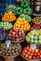 Naklejka na ściany i meble Funchal - Madeira, 20.09.2019. Vertical photo of fruit store with apples, kiwi, peaches, bananas.