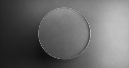 An empty round gray plate on a dark gray background. The view from the top