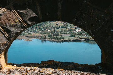 Beautiful shot of tranquil lake and beach through an arch