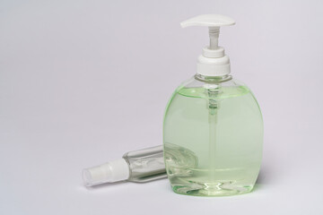 group of hand sanitizer spray or liquid soap bottles over light grey background