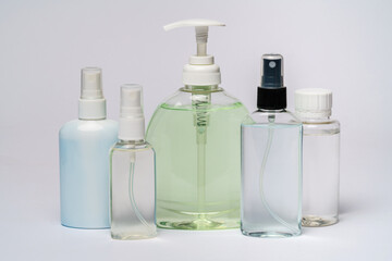 group of hand sanitizer spray or liquid soap bottles over light grey background