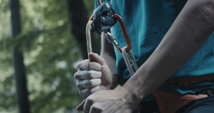 Climber protect rock climb partner pull brake by hand belay lead rope equipment safety gear for outdoors lifestyle sport in nature unrecognizable extreme close up