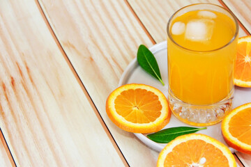 orange drink in a glass and round orange slices
