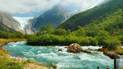 Briksdal glacier with a mountain river in the foreground. The amazing nature of Norway