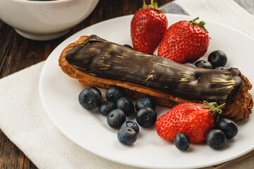 Eclair cake with chocolate glaze on wooden tray