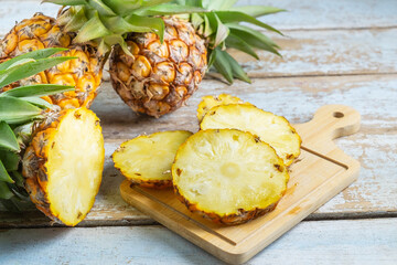Fresh pineapple fruit sliced ​​on a wooden cutting board