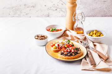 Delicious bruschettas with mushrooms, blue cheese, olives and tomatoes