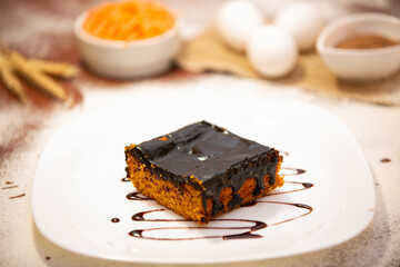 Carrot cake with chocolate and slice on the table.