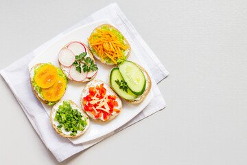 Sandwiches or tapas of their white bread with delicious healthy ingredients on a napkin, on a white background. Can be used for Breakfast.