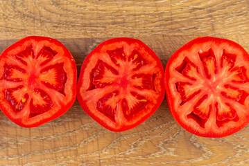 Ripe, sliced tomatoes on a wooden board.