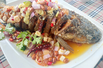 fried Snakehead fish with herb and spicy sauce, thai food.