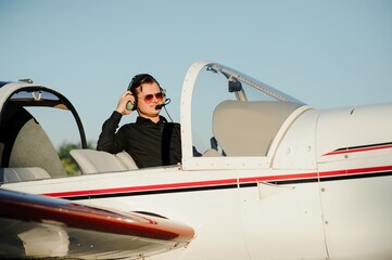 Portrait of confident young man pilot in small plane © Serhii