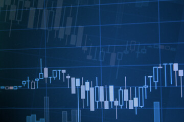 Closeup financial stock chart with uptrend line candlestick graph in stock market on blue color monitor