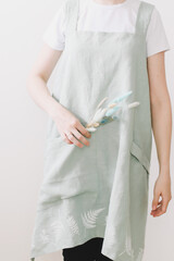 Girl wearing Japanese linen apron. Cooking at home. Kitchen textile. linen fabric 