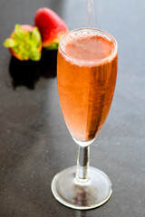 A glass of rose wine with strawberries