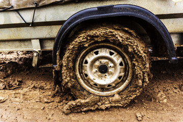 Dirty car wheel. Lack of paved roads. Close-up.